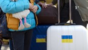 Close-up of Ukrainian immigrants with luggage waiting at train station.