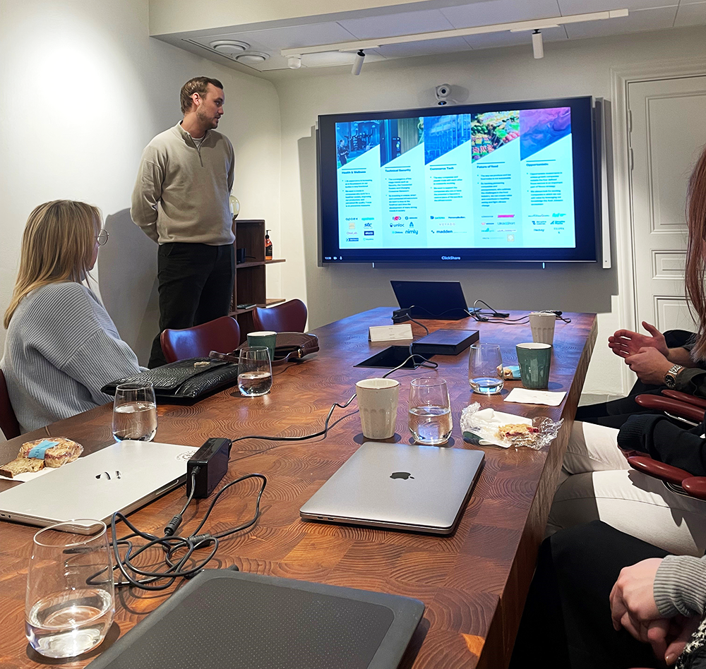 An  Investment Associate from  Novax, holds a workshop in front of students in a confereance room.