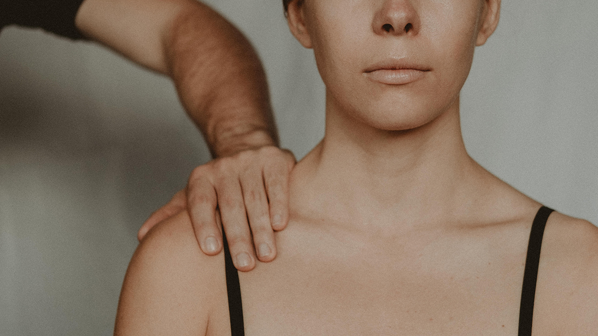 Man holding a woman's shoulder.