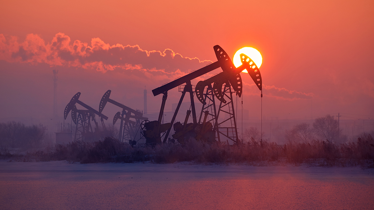 The oil pumping units by lakeside sunrise.