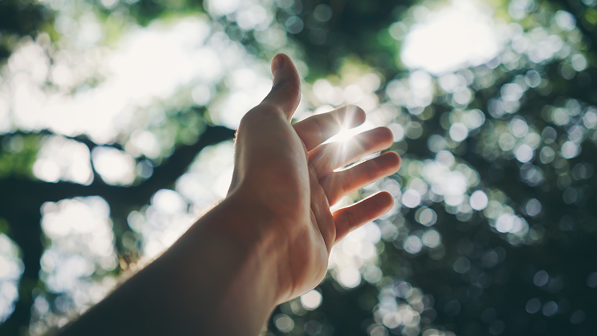 Hand reaching out to the sky