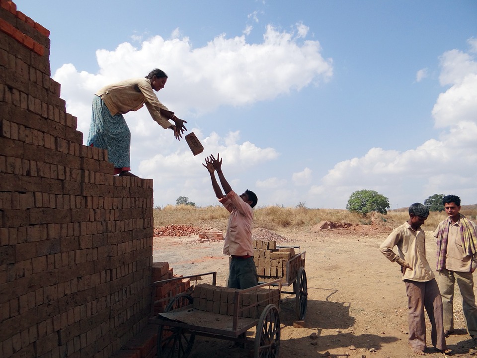 Workers building brick wall