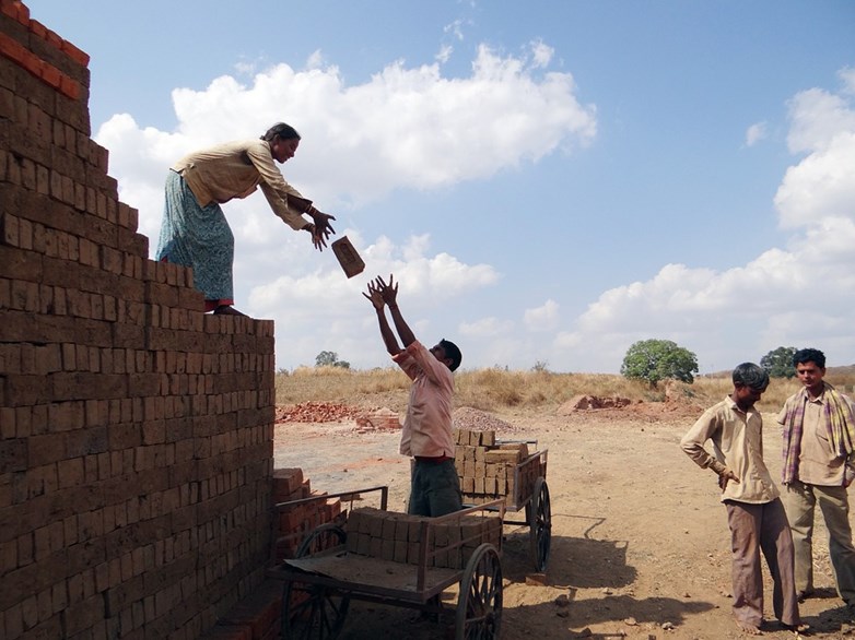 Workers building brick wall