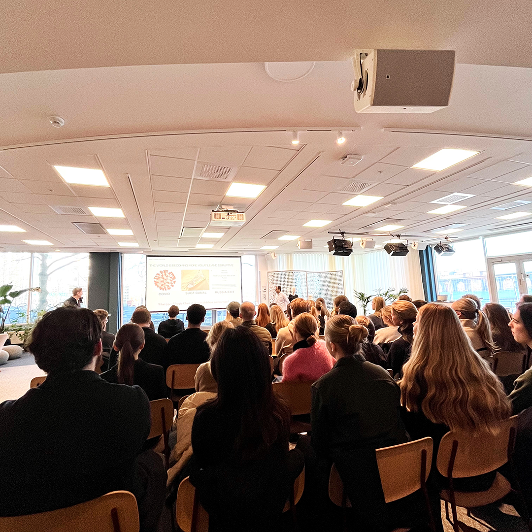 Students in a large konferens room listening to a presenter from H&M.