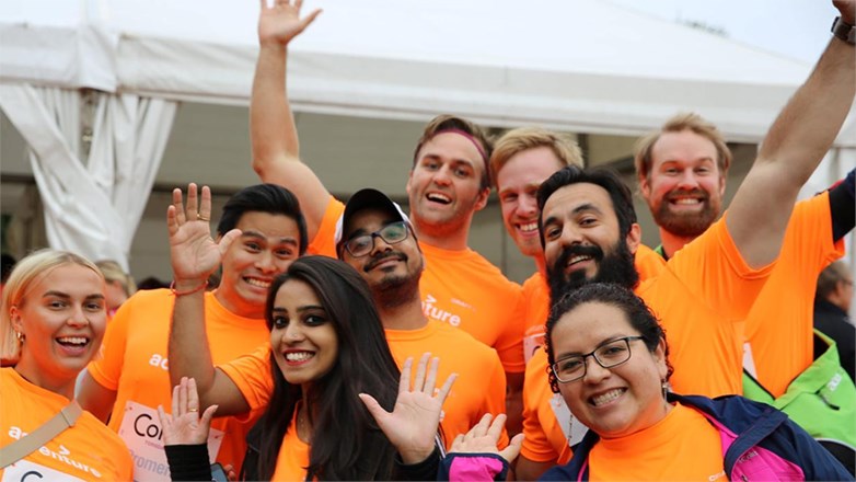 Picture showing several Accenture employees dressed in orange t-shirts at a running race.