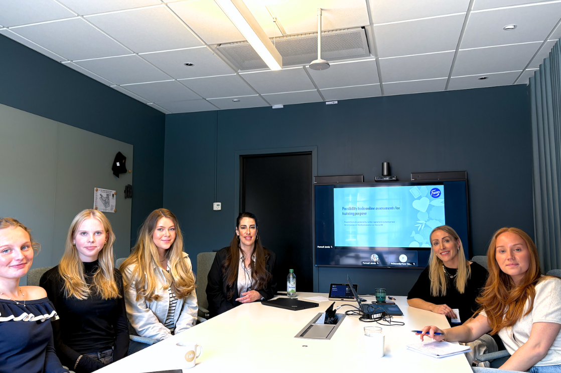 Small group of students sitting around a conferenace table with representatives from Fazer.