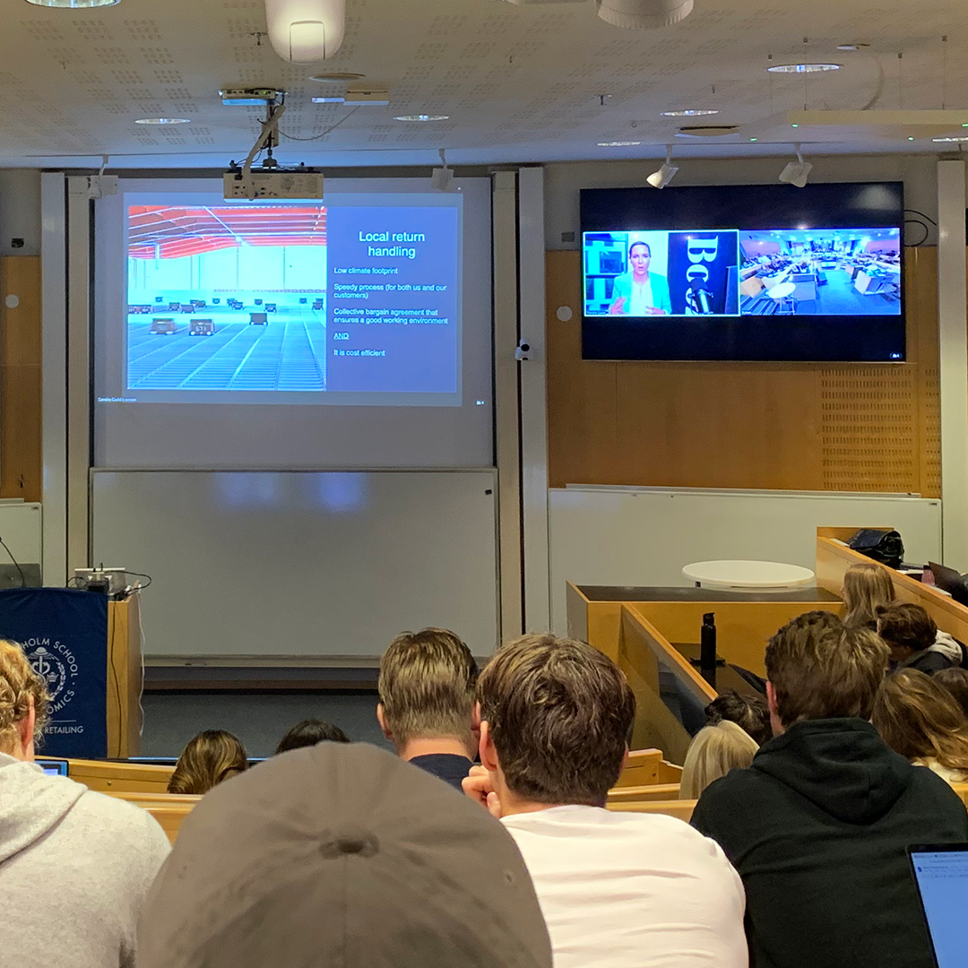 Students listening to a presentation  projected online on scrren in a lecture room