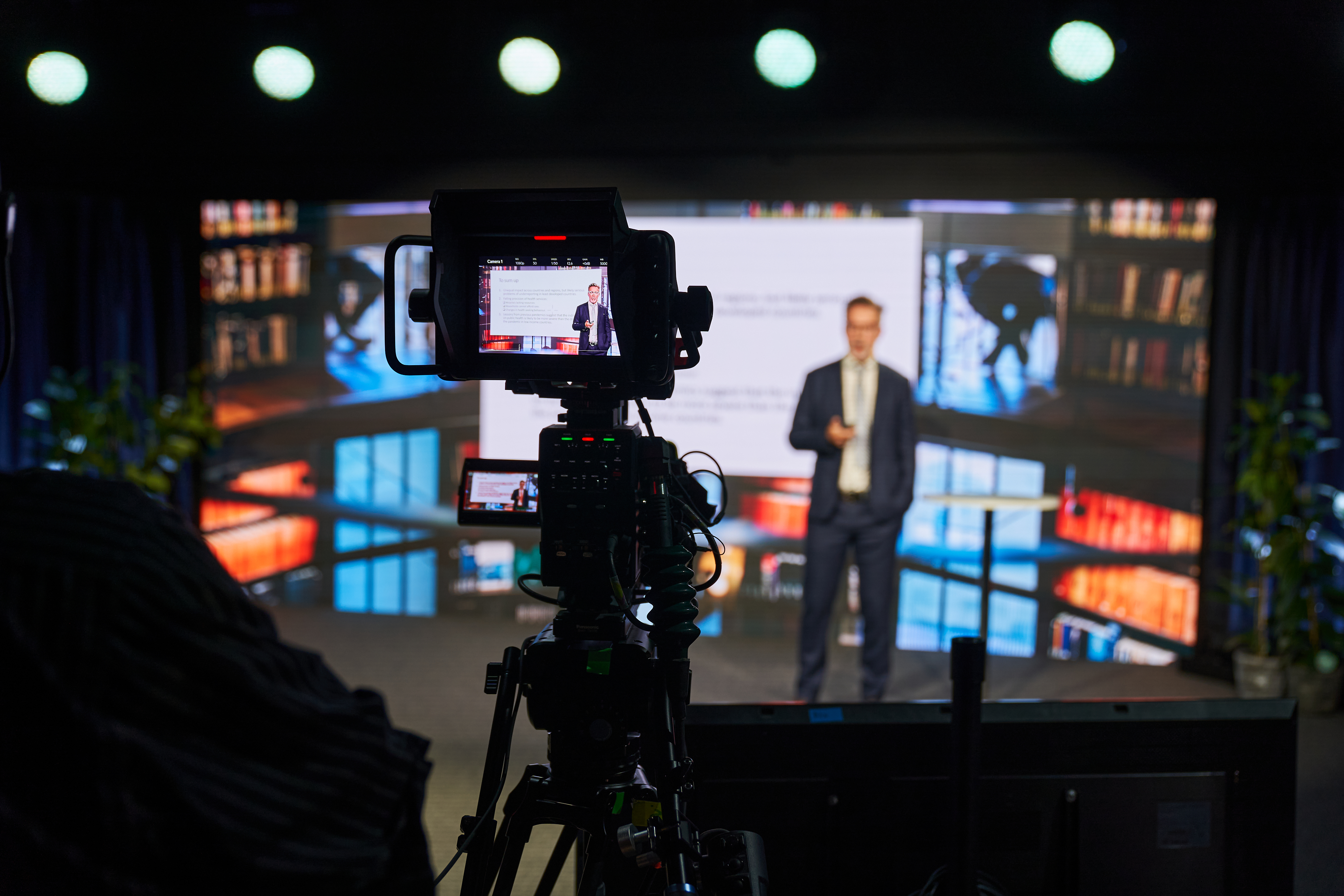 Man standing on stage being filmed