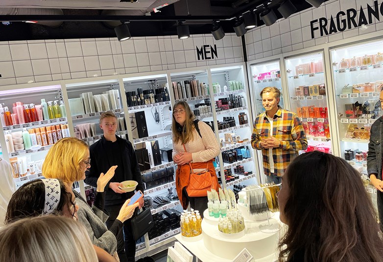 Students and a company representative standing i one of Lyco's cosmetics stores having a talk.