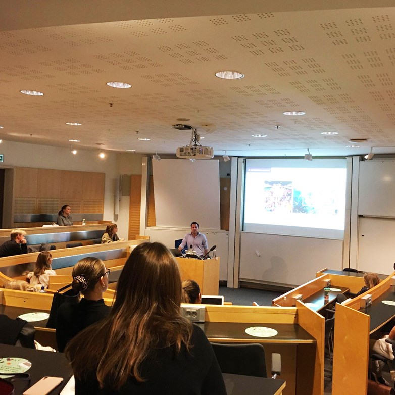 A representative from the company Accenture holds a lecture in front of students in a lecture room