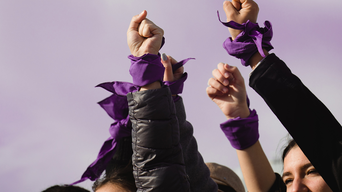 women empowerment : strong women defending rights on 8 march demonstration. Purple colours.