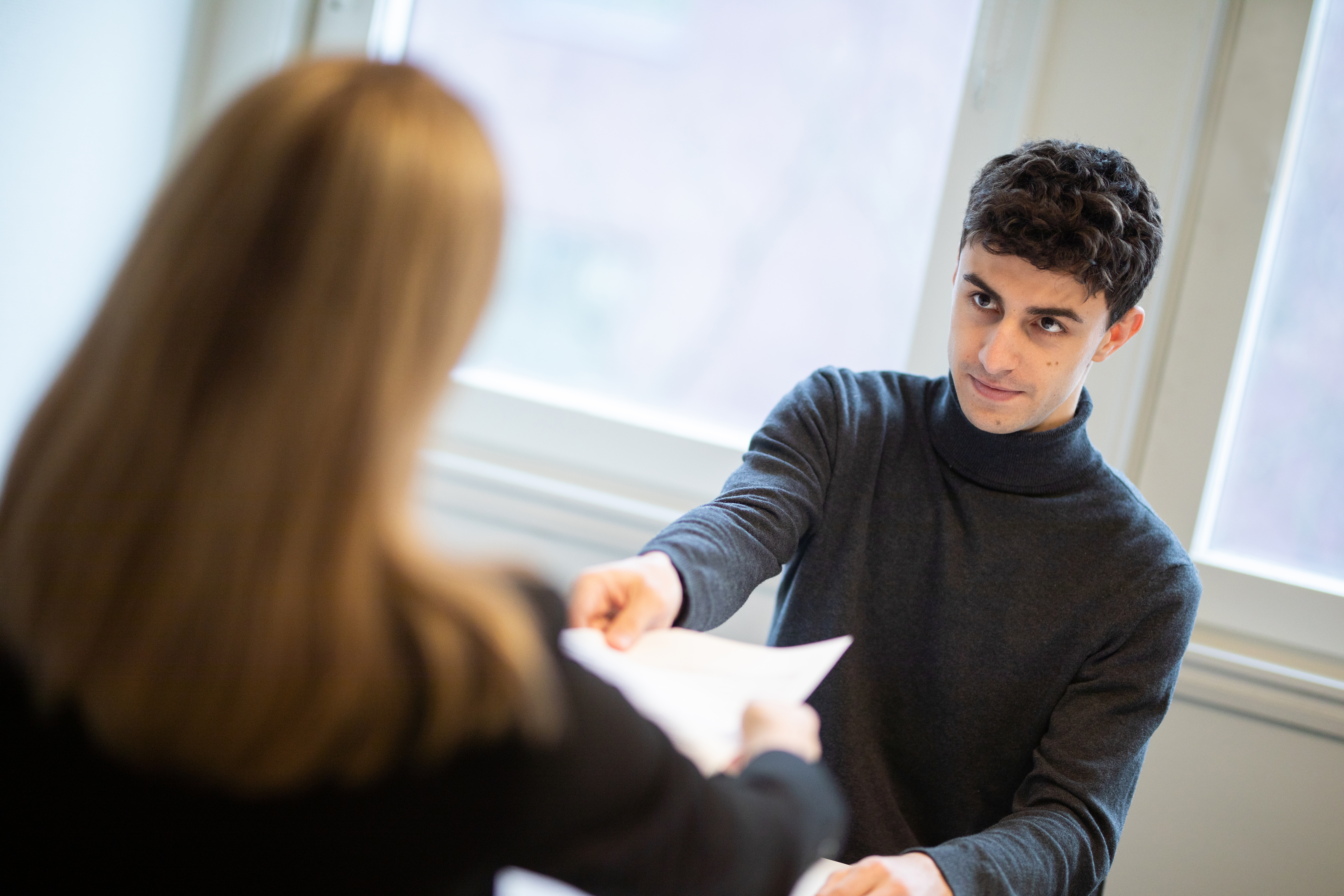 Man handing woman a piece of paper
