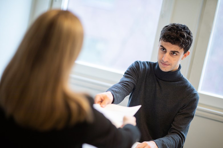 Man handing woman a piece of paper