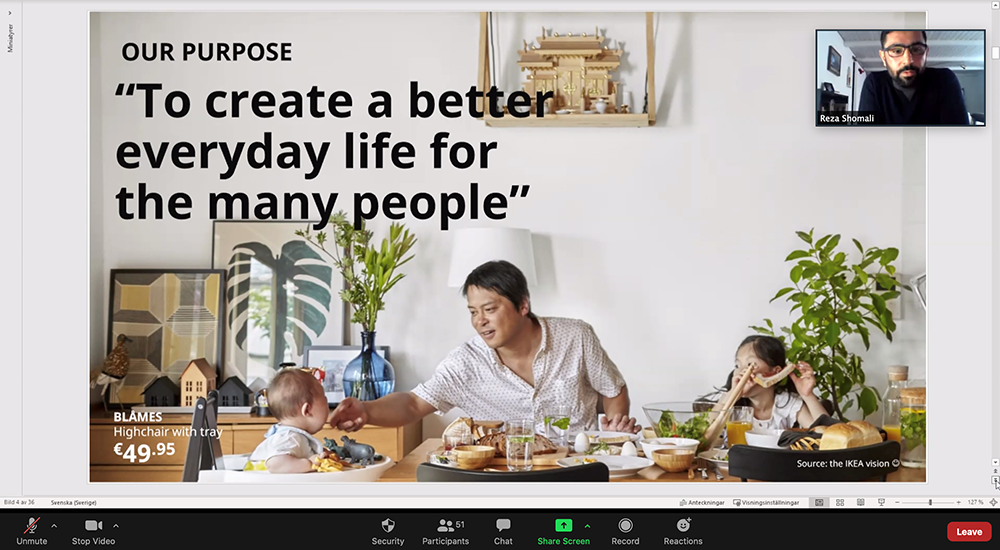 PPT zoom clip with presenter in a small picture in a slide covering a family where the father feeding his child in a IKEA furnished kitchen.