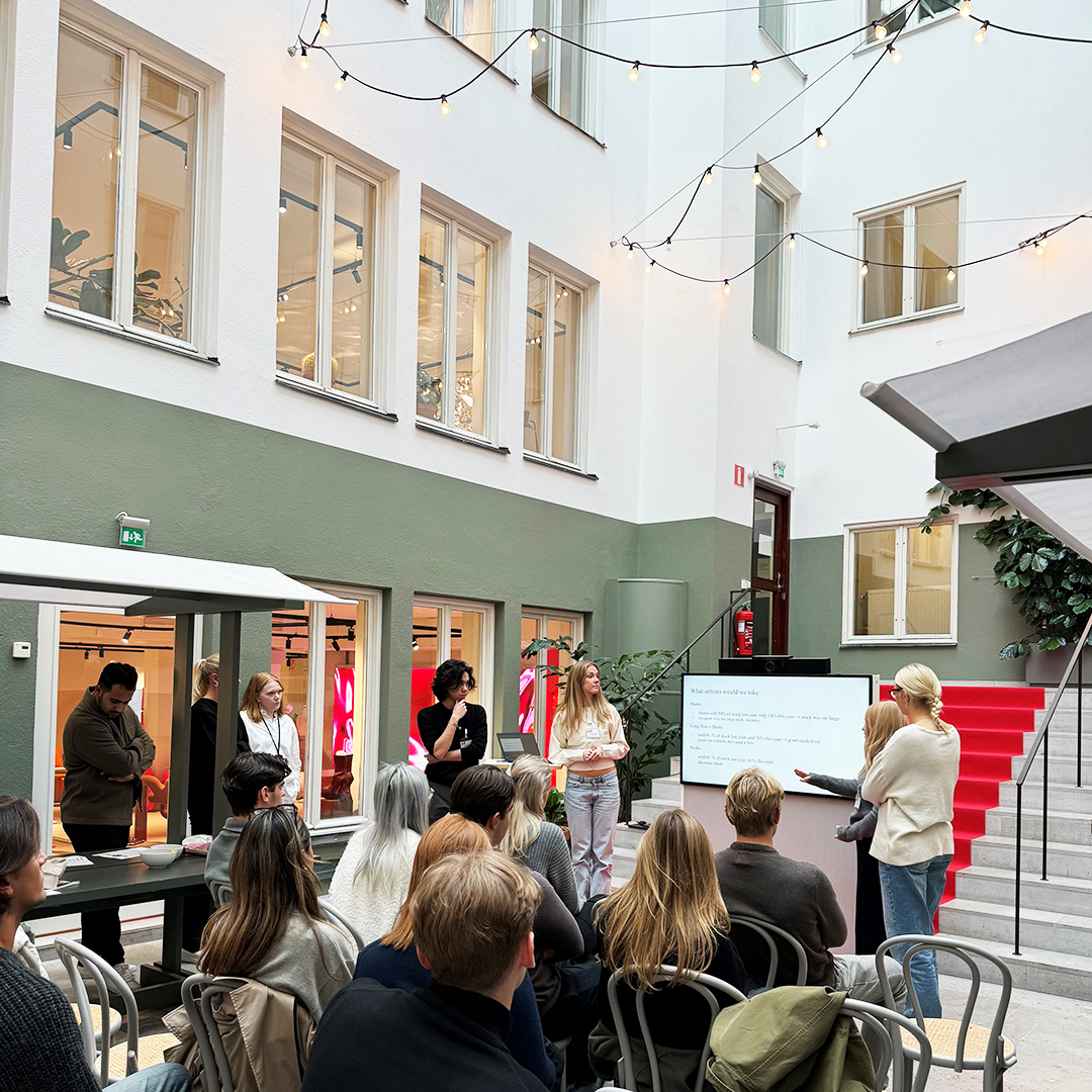 Students presenting in an atrium at H&M HQ, Stockholm.