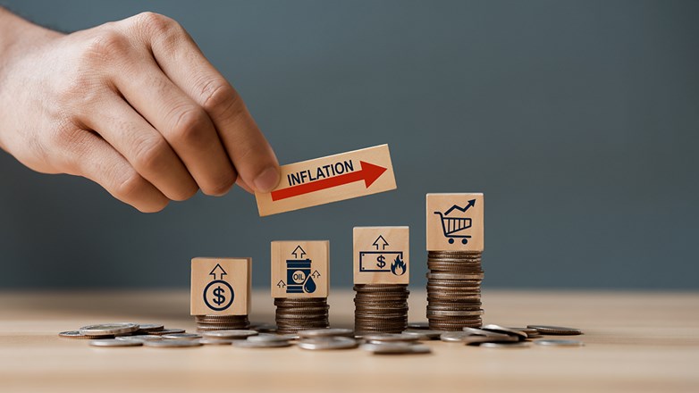 Hand putting wooden cube and inflation word a on coins in idea for FED consider interest rate hike, world economics, and inflation control, US dollar inflation