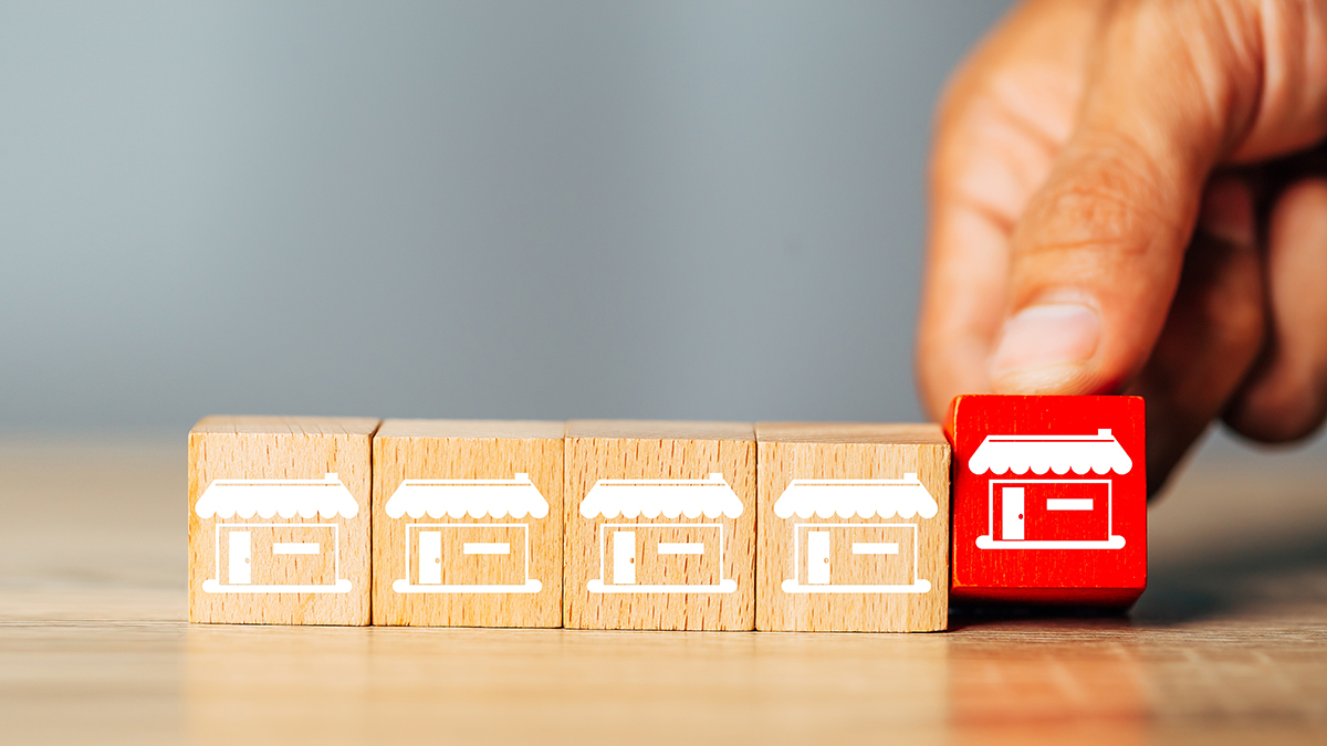 Cubes wood Franchise business,Businessman hand choose wooden blog with franchise marketing store icons.