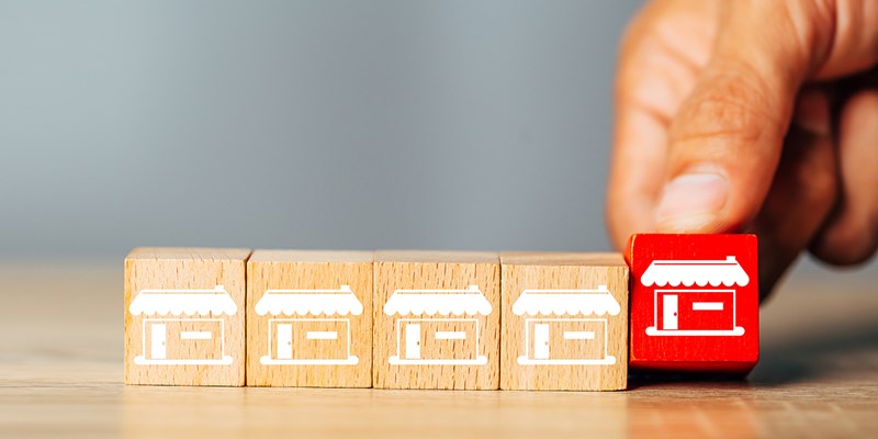 Cubes wood Franchise business,Businessman hand choose wooden blog with franchise marketing store icons.