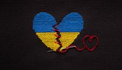 Broken heart the color of the flag of Ukraine embroidered on a black background.