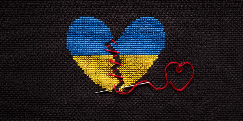 Broken heart the color of the flag of Ukraine embroidered on a black background.