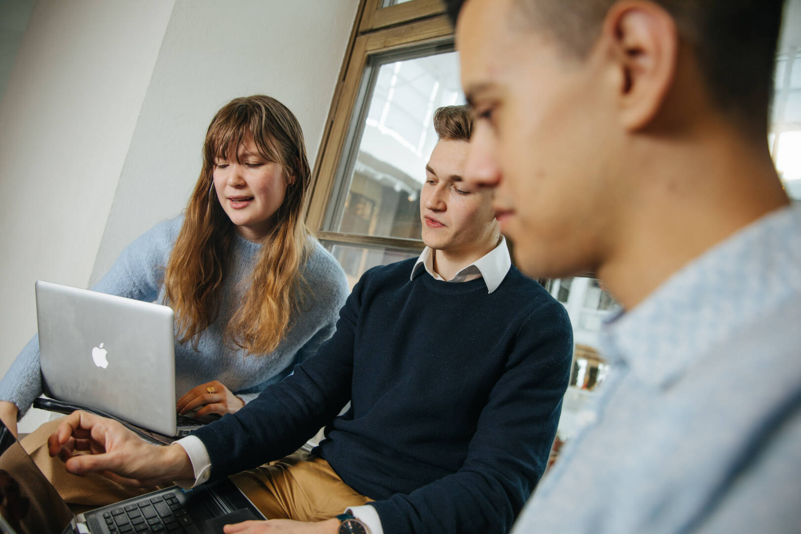 group or 3 people looking at laptop screen