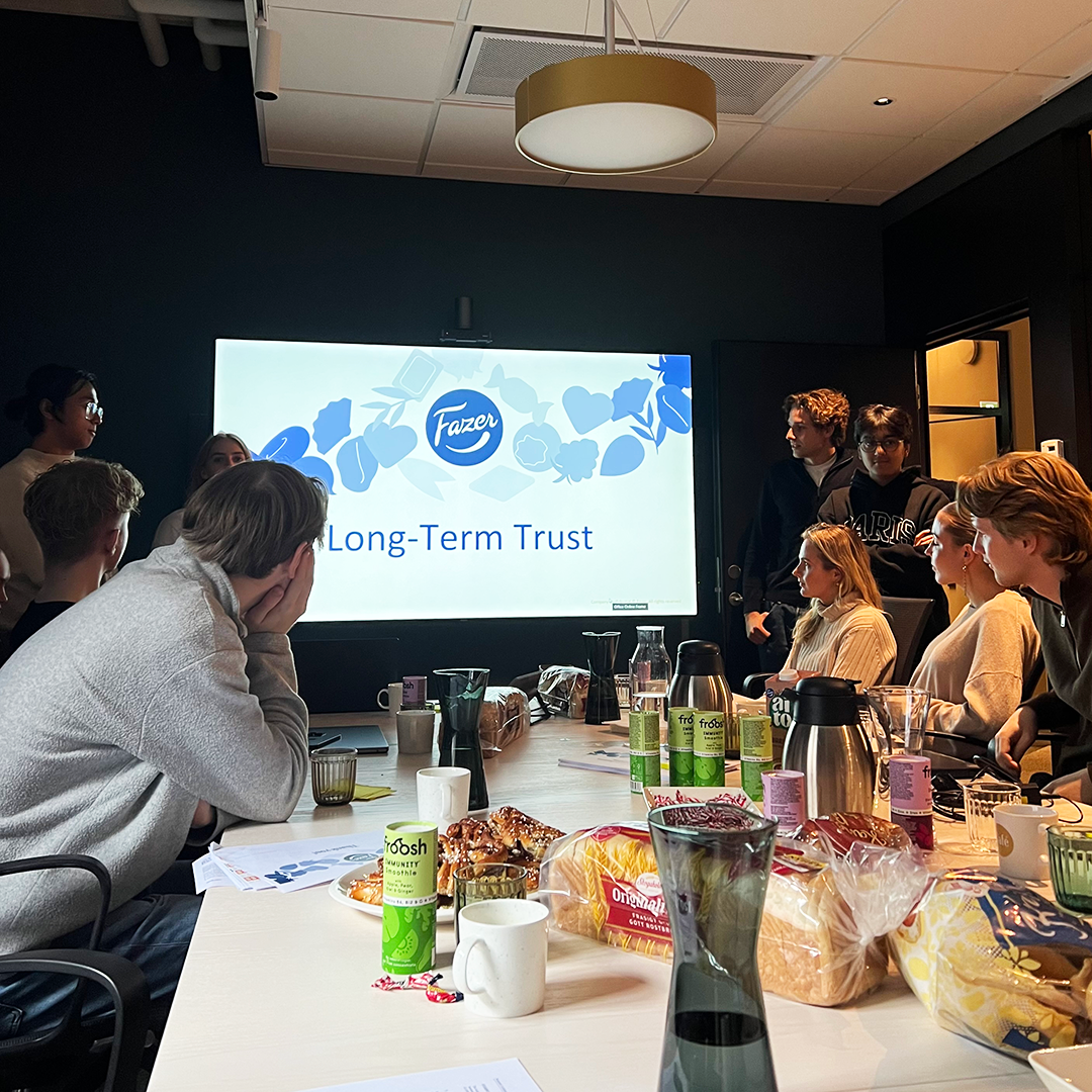 Students sitting a around a table in a cosy conference environment