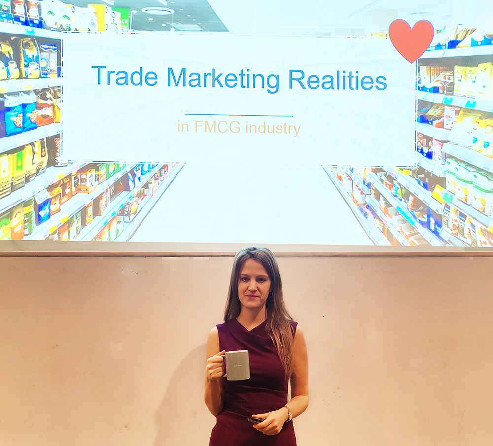 Liene Grizane, Swedish Match standing in front of a ppt slide and holding a coffee cup.
