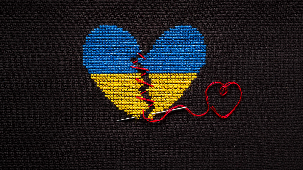 Broken heart the color of the flag of Ukraine embroidered on a black background.