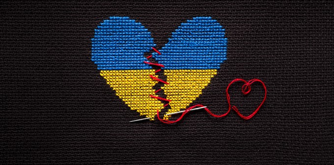 Broken heart the color of the flag of Ukraine embroidered on a black background.