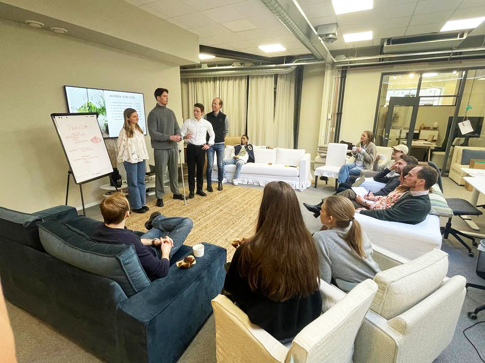 Group of students presenting at a workshop with Bemz. An audience is sitting listening in comfy chairs.