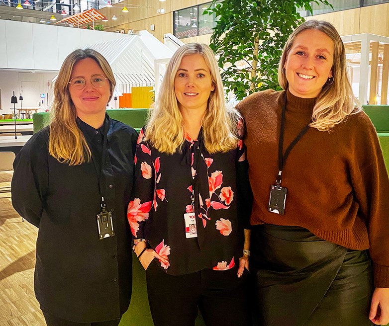 Three female represenatives from ICA Gruppen standing close to eachoter side by side looking and smiling in to the camera.