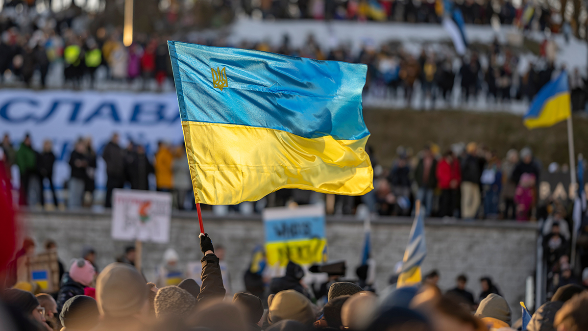 activist or protester holding a Ukrainian flag at a public demonstration or meeting supporting Ukraine in Estonia, Tallinn