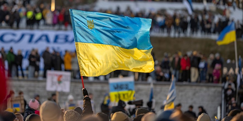 activist or protester holding a Ukrainian flag at a public demonstration or meeting supporting Ukraine in Estonia, Tallinn