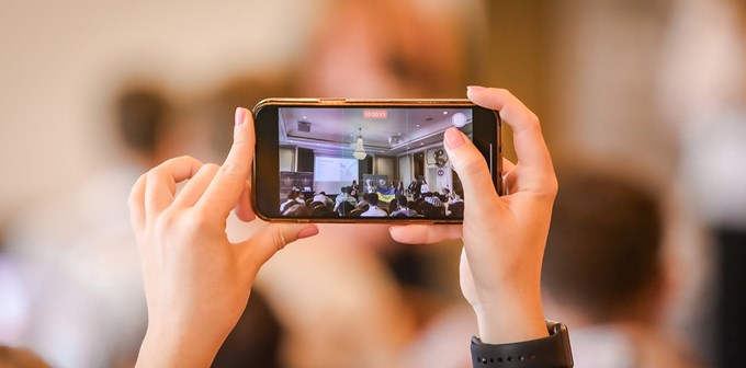 A woman taking a photo via her smart phone