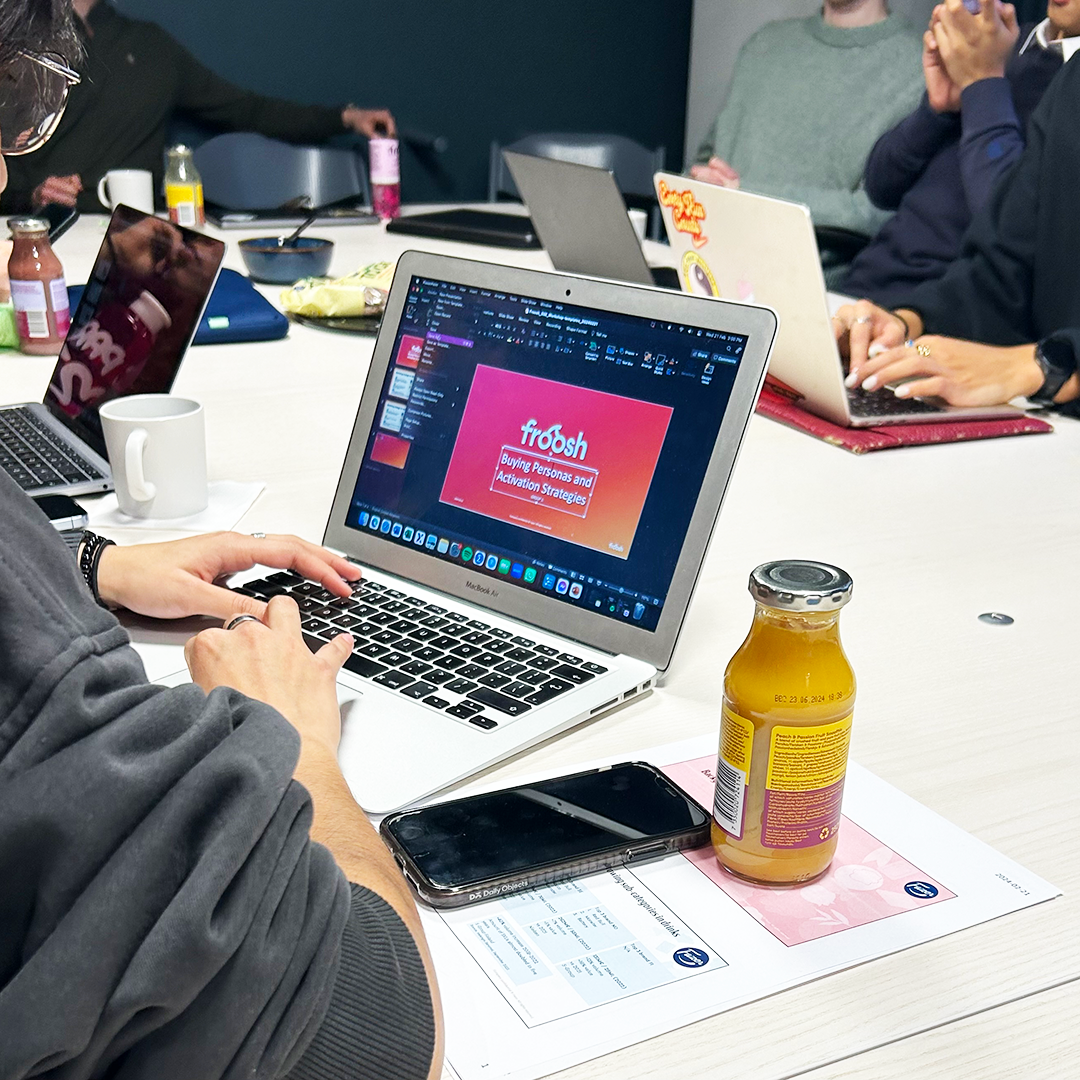 A student sitting in front of a laptop creating a ppt in a cosy lit room.