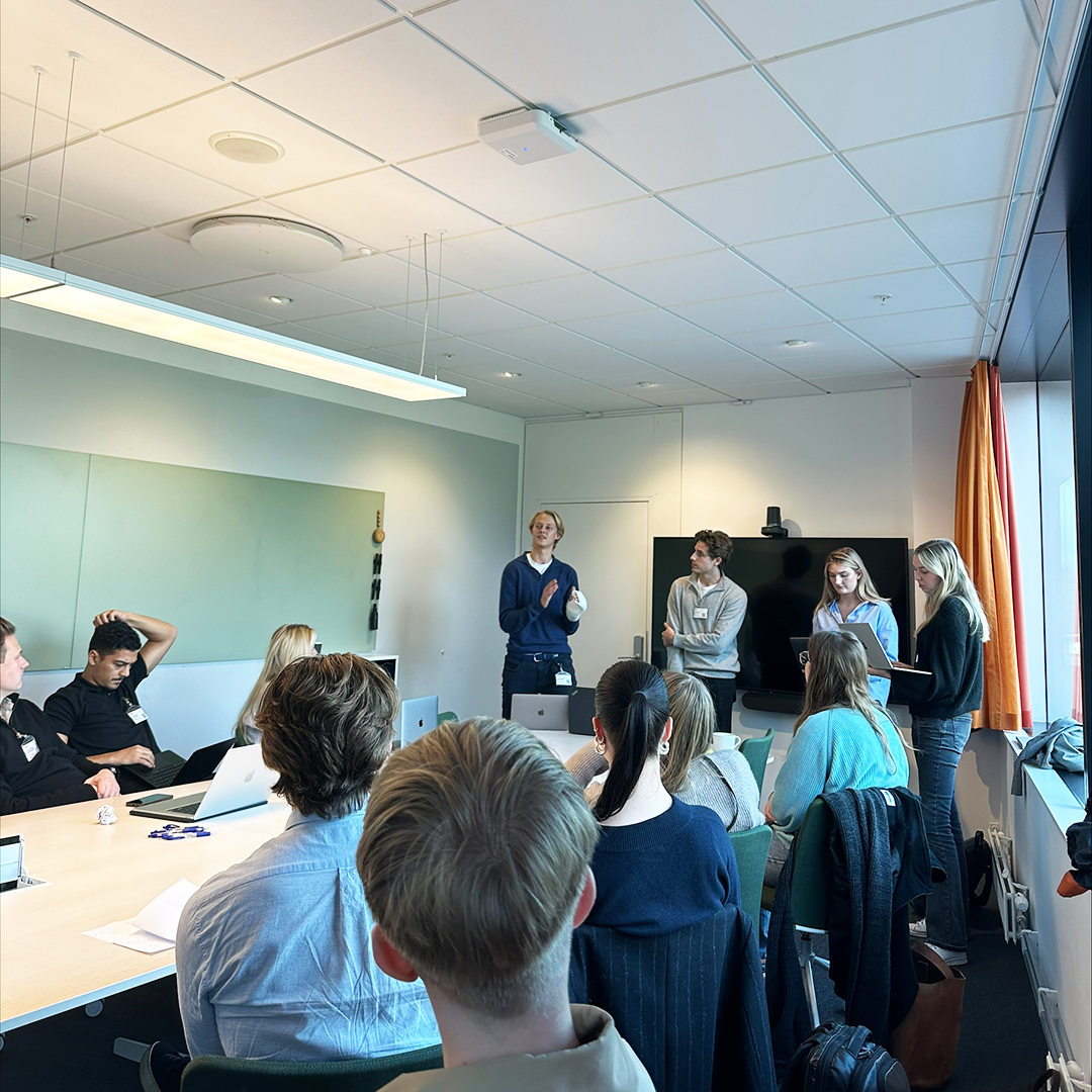 Students presenting in front a group of other students at ICA's HQ.