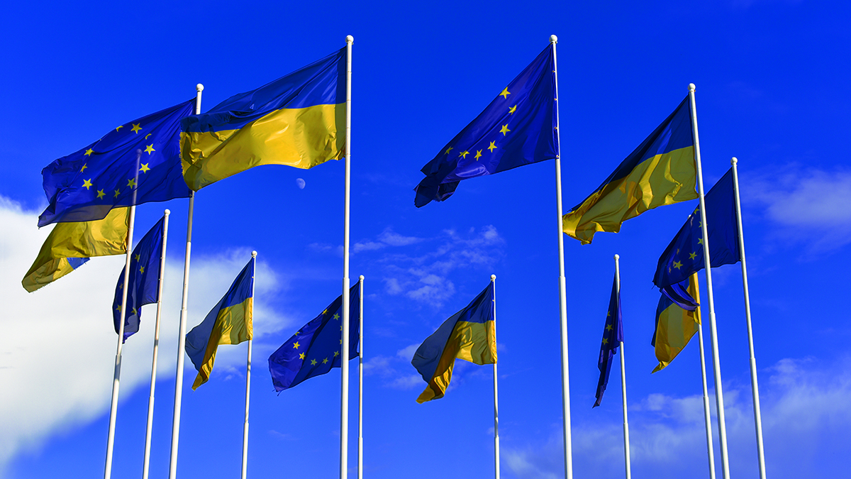 Flags of Ukraine and EU on sky background