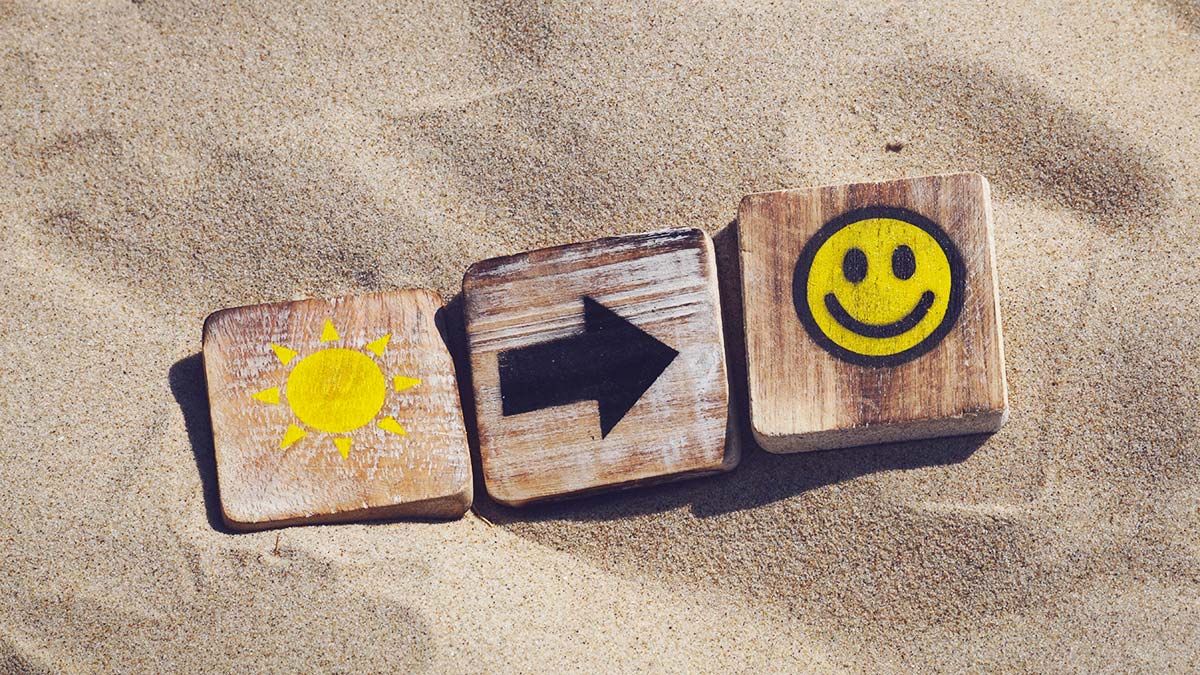 Three cubes depicting a sun, arrow and a smiley face.