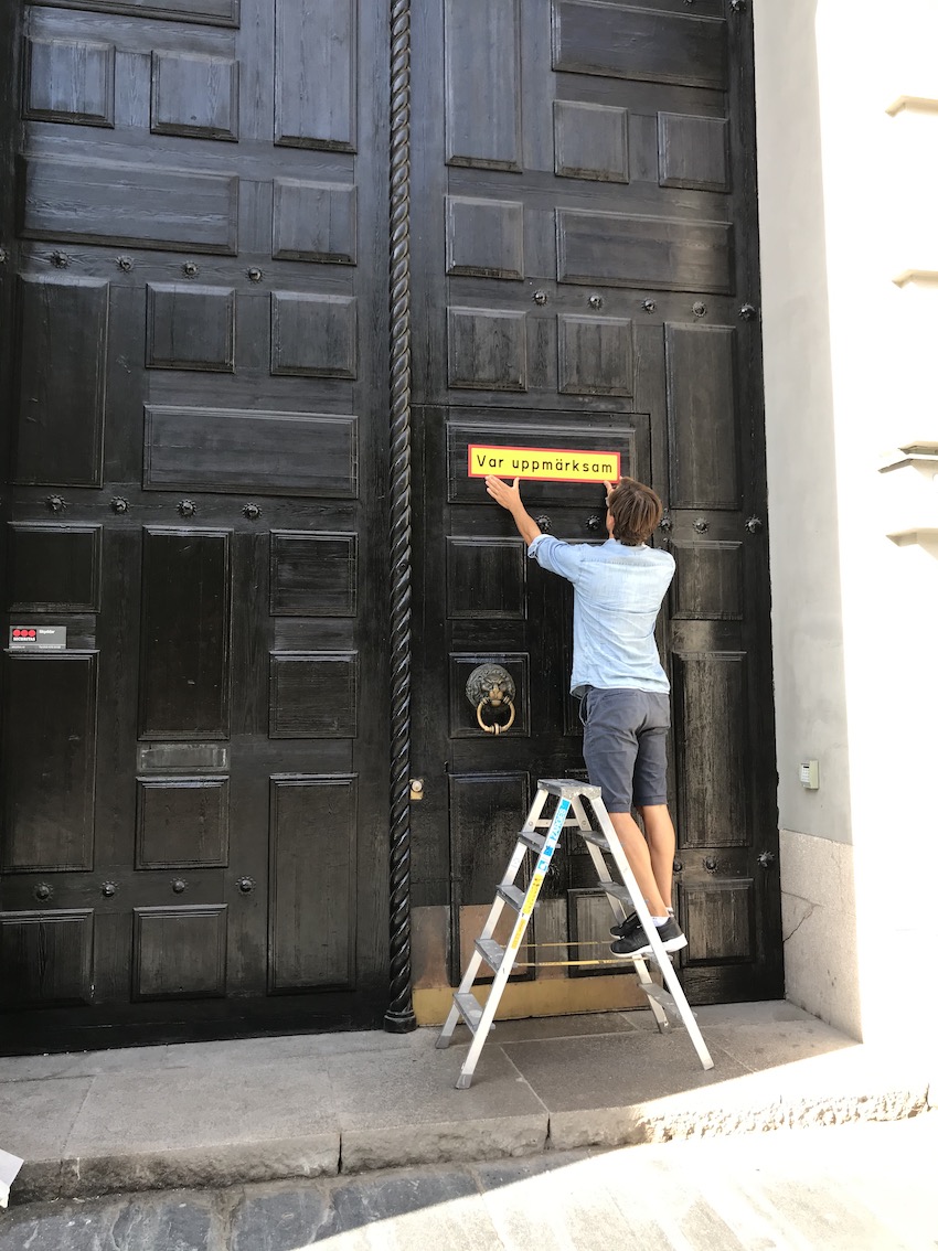 August Eriksson installing his artwork Pay attention