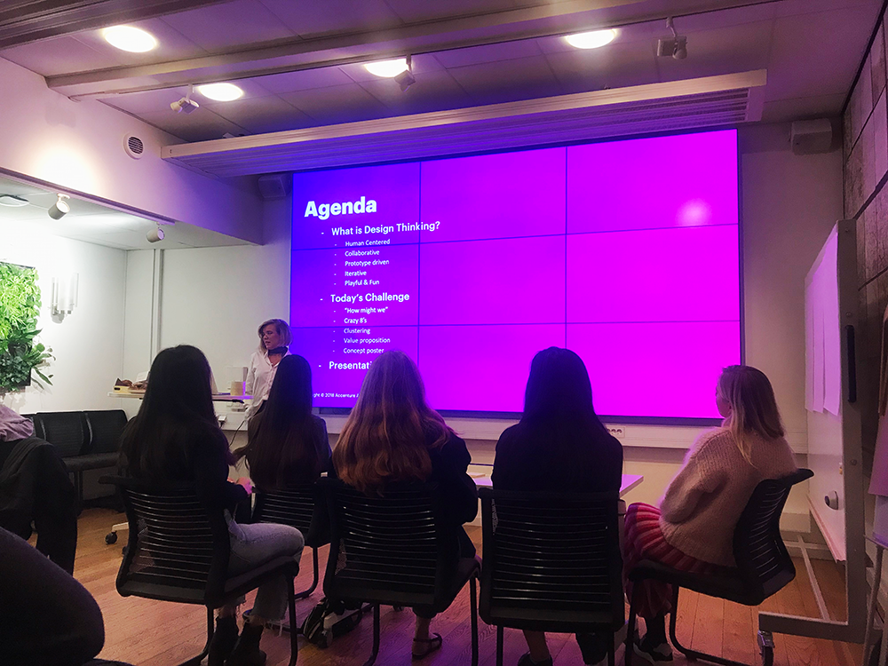 Woman from Accenture present the workshop agenda on ppt to a audience of students