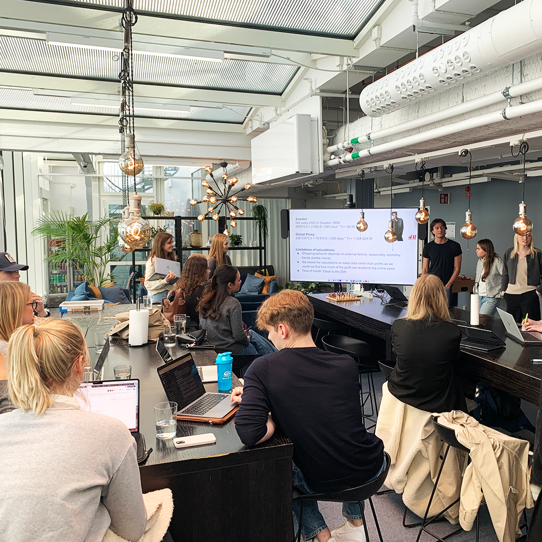 Students looking busy in a workshop in an open high ceiling office space.