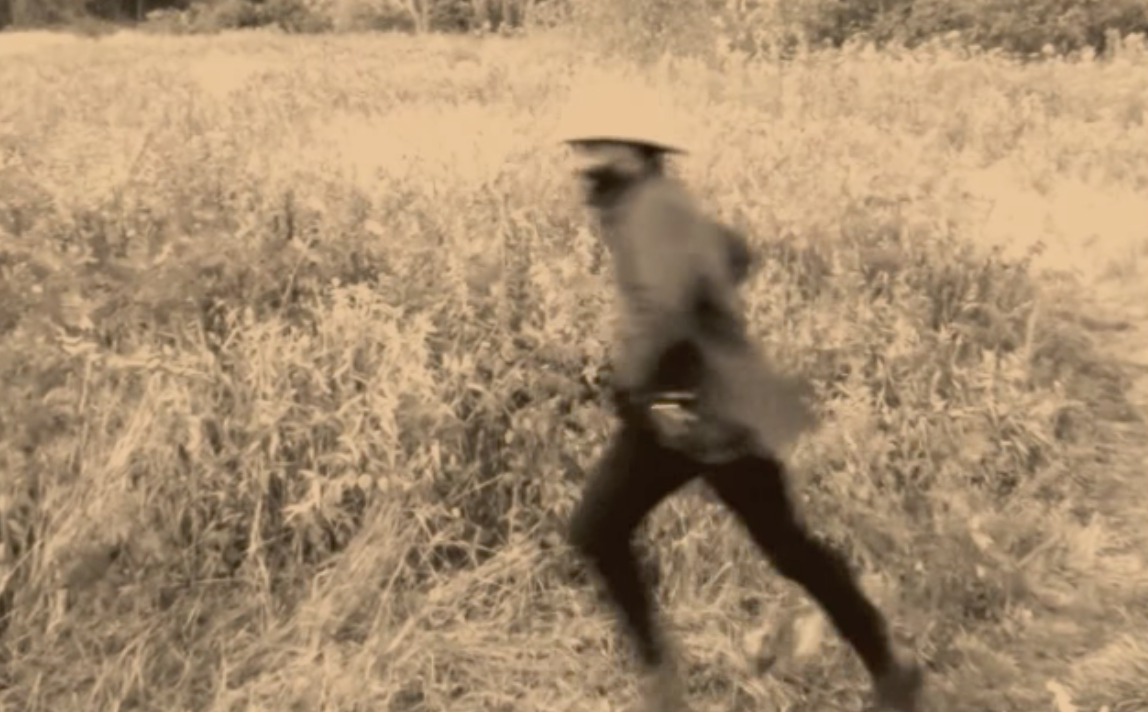 Still from Samson Kambalu's video Runner, showing a man running