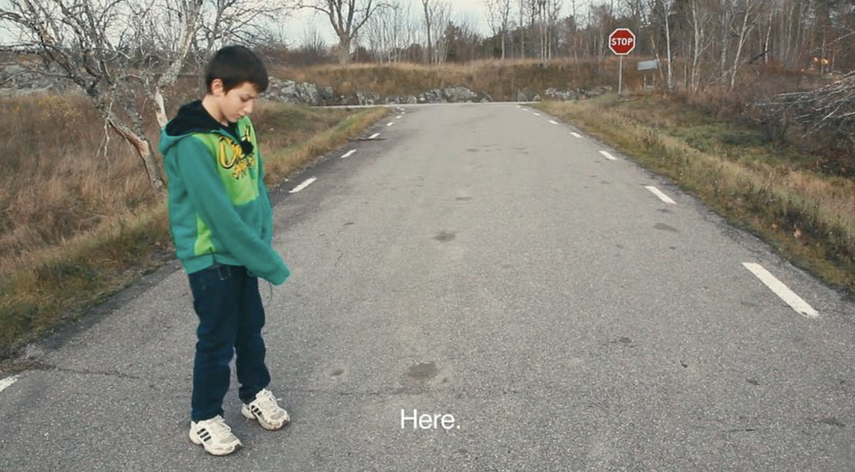 Still from Knutte Wester's video Where the Border Runs, showing a boy in the Swedish landscape