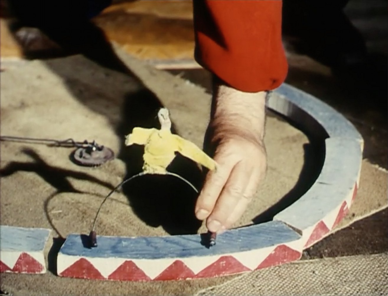Alexander Calder crouched over his miniature circus, working the wire figures by hand.