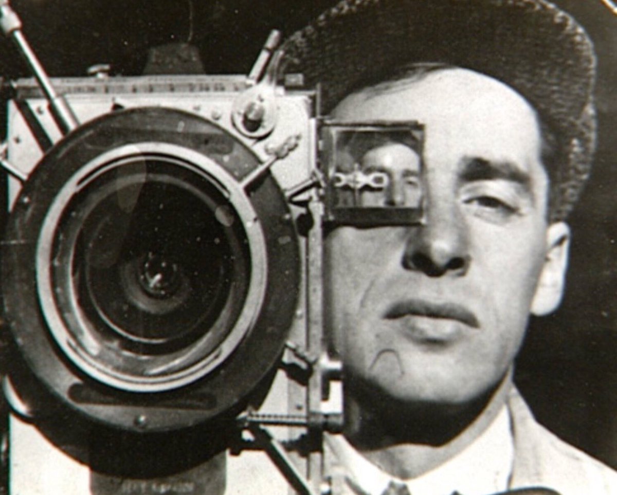 Still from the 1929 film: a cameraman perched with his tripod-mounted camera above the city, the shot that gives the film its title.