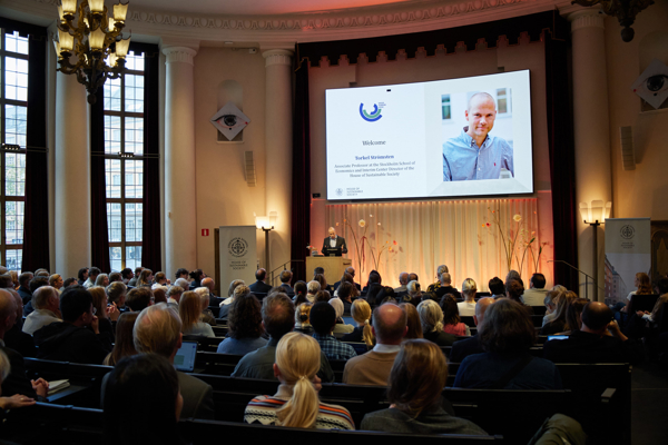The interim Center Director of the House of Sustainable Society, Torkel Strömsten, stands on the stage in the Aula at the Stockholm School of Economics to welcome everyone to the HoSS Forum 2026.