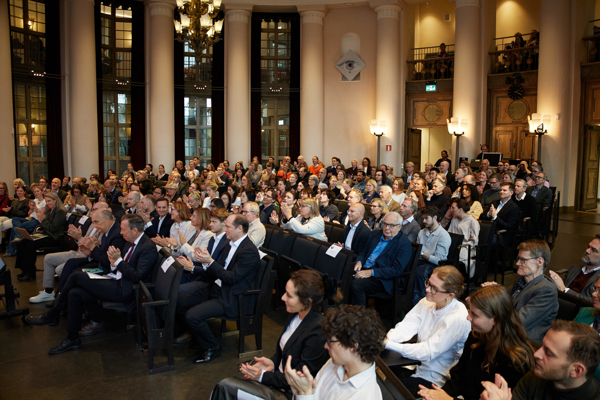 The audience claps their hands in a packed Aula at the Stockholm School of Economics during the HoSS Forum 2026.