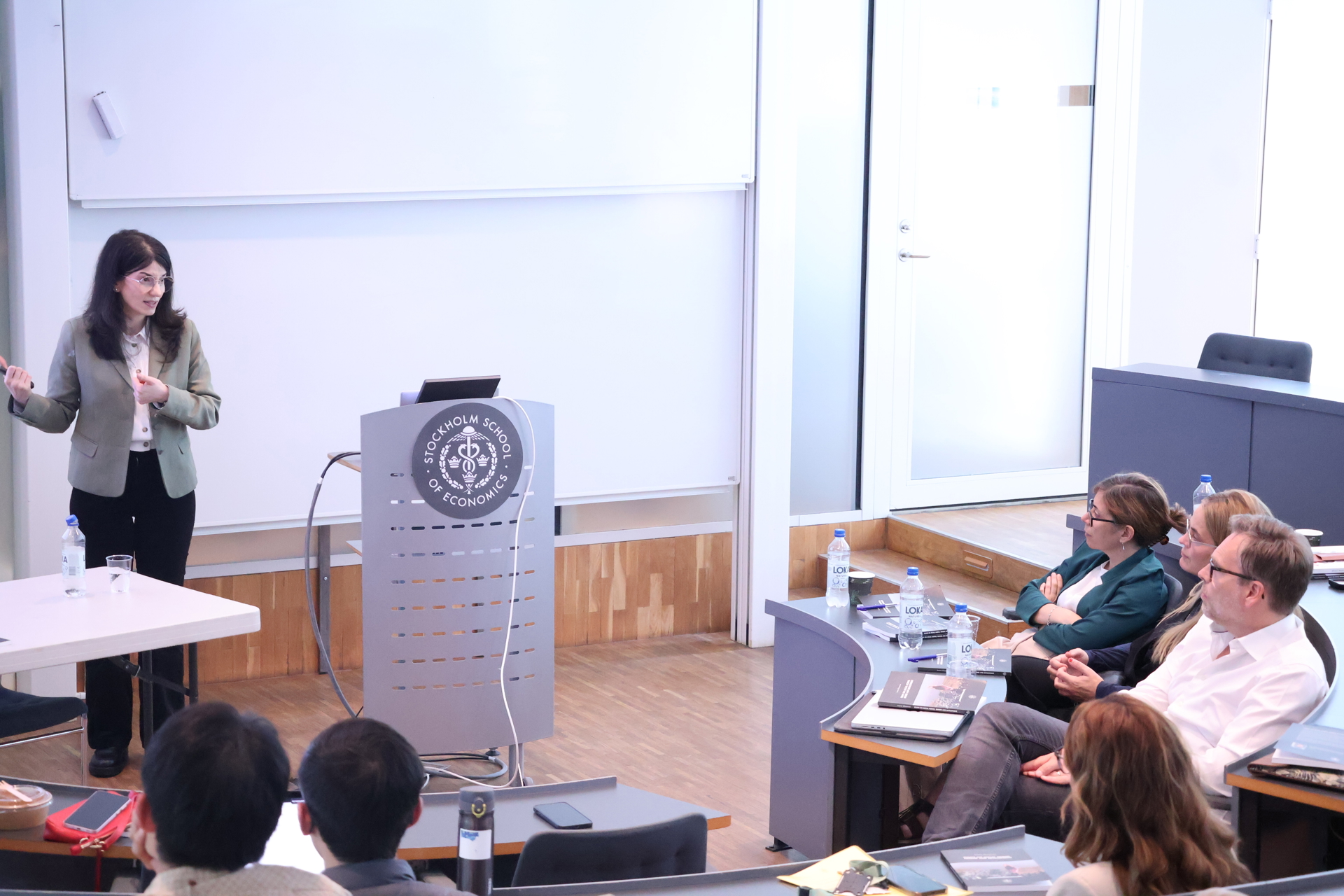 Avenia Ghazarian standing in front of the assessment committee presenting her doctoral dissertation at her defense.
