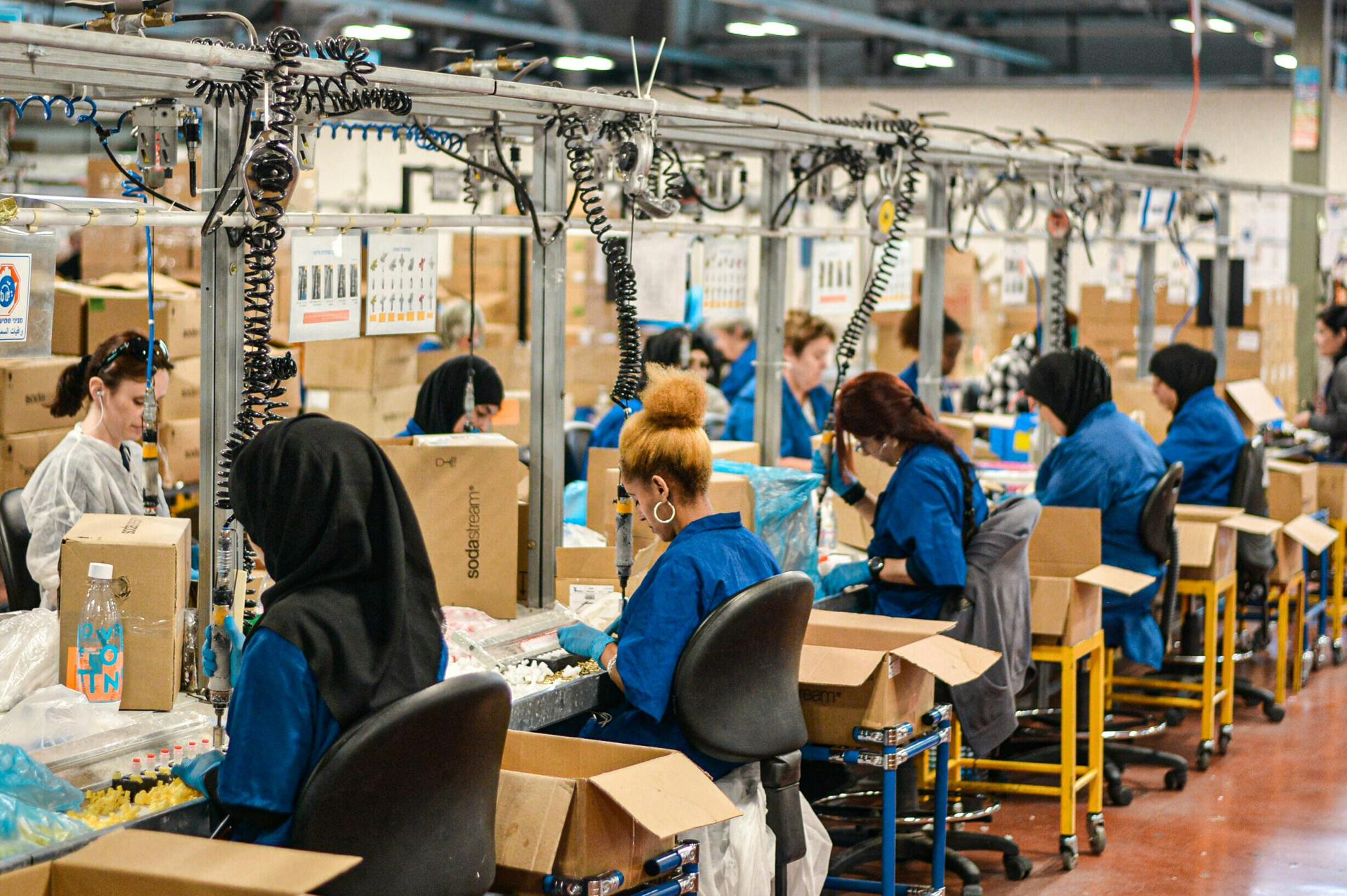 Women sitting in rows working at sewing machines in an apparel manufacturing factory