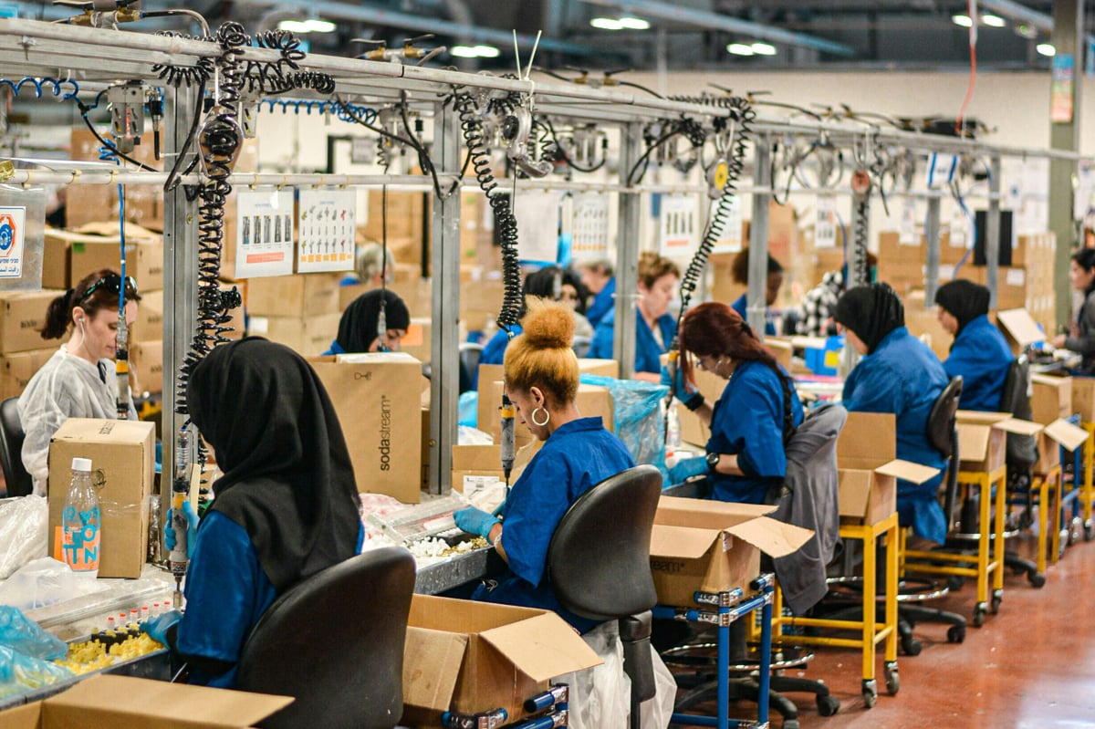 Women sitting in rows working at sewing machines in an apparel manufacturing factory